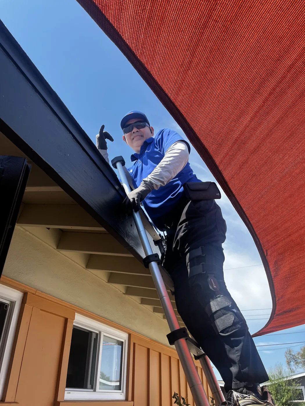 CrossBreeze technician climbing to the roof edge of a single story home